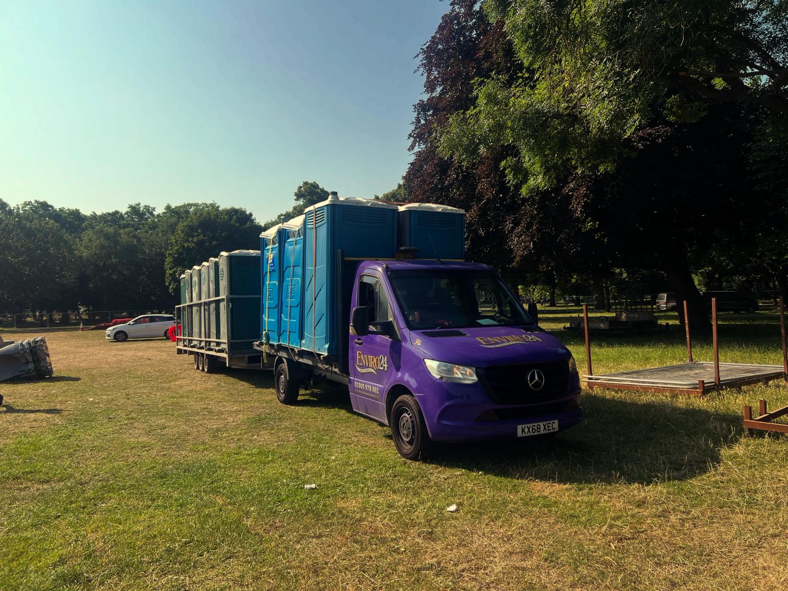 Enviro24 branded purple van delivering portable toilets to an outdoor event in Leicester on a sunny day